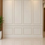 White wall with decorative rectangular molding panels and a horizontal chair rail divider.