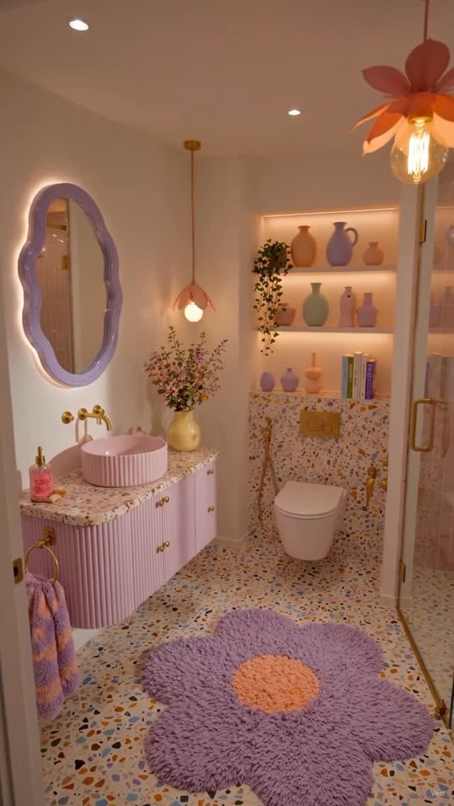A pastel lavender bathroom featuring colorful terrazzo flooring and a large purple flower-shaped rug.