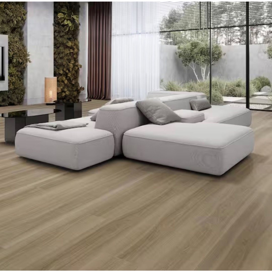 Light wood wide plank flooring in a modern living room with a grey modular sofa.