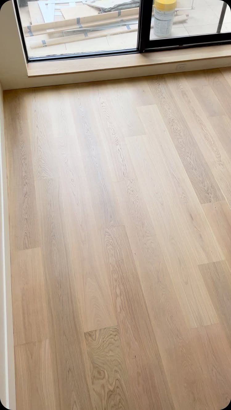 11 Whole House Flooring Ideas That Work from Entry to Bedroom 10 Light natural oak hardwood flooring planks installed in a bright room near a window.