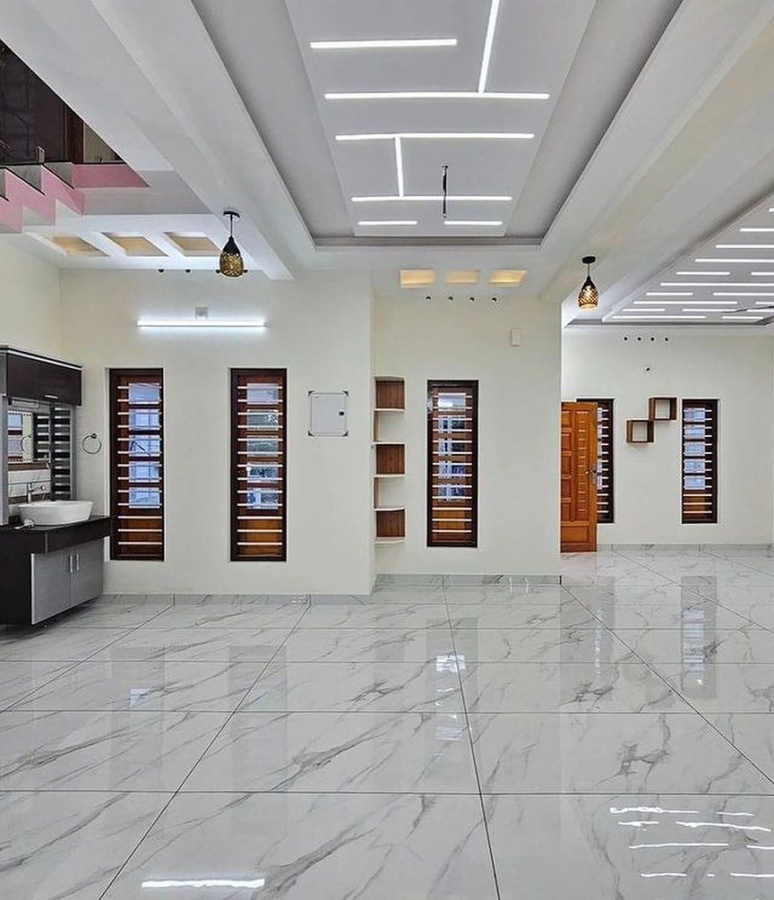 11 Whole House Flooring Ideas That Work from Entry to Bedroom 2 Large white marble-patterned tiles covering the floor of a modern, brightly lit empty room.